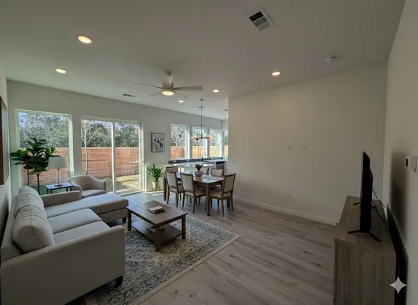 a living room with furniture a large window and a table