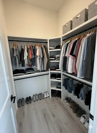 a view of walk in closet with clothes and shoes