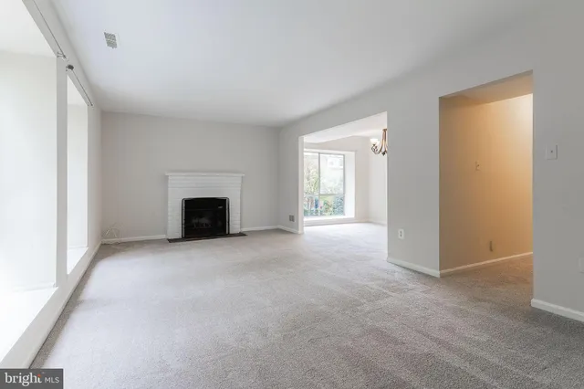 an empty room with a fireplace and a window