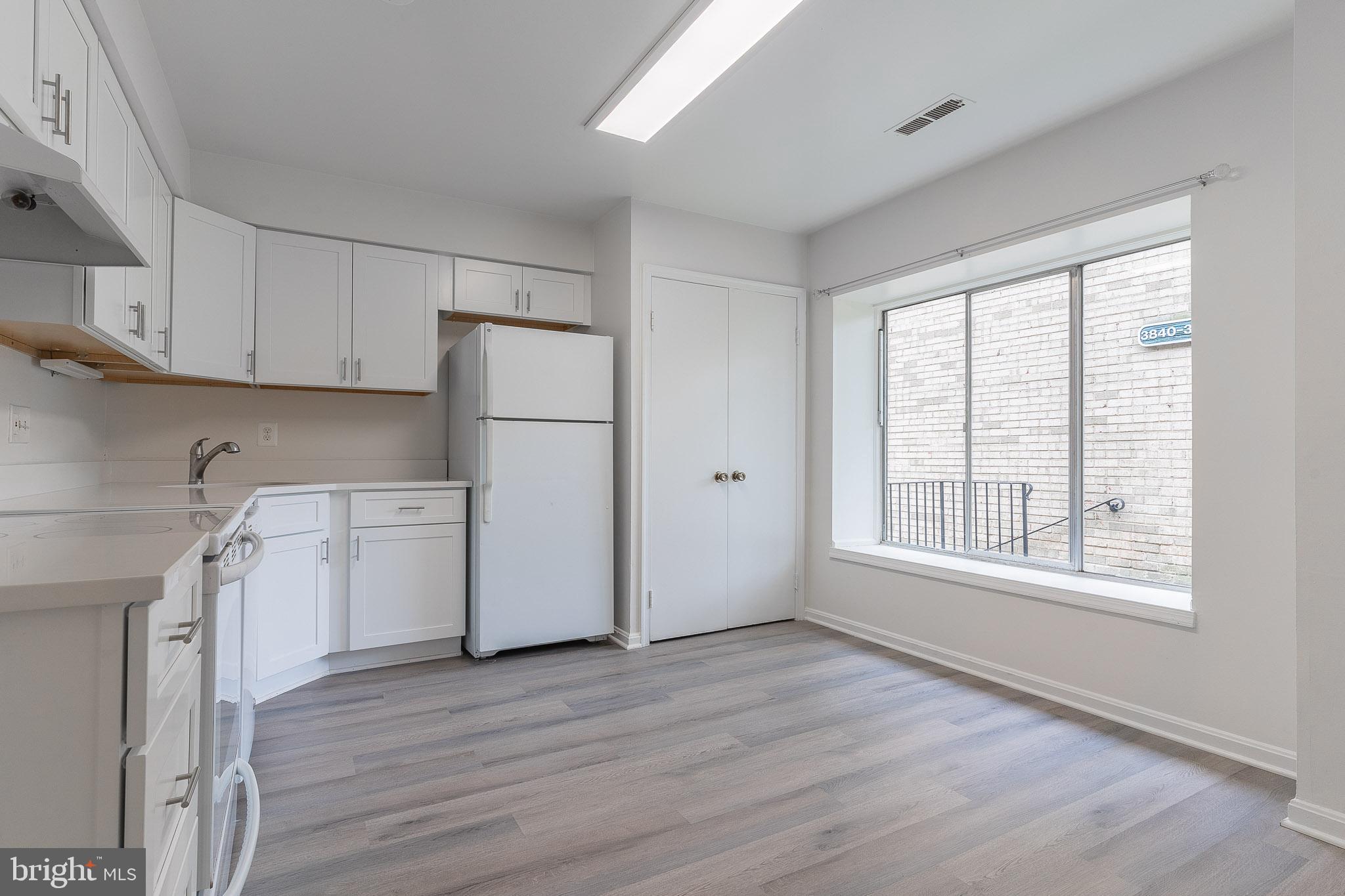 3840 Persimmon Circle Fairfax, VA 22031 - Photo 5 of 25 a kitchen with a refrigerator a stove top oven a sink and dishwasher with wooden floor