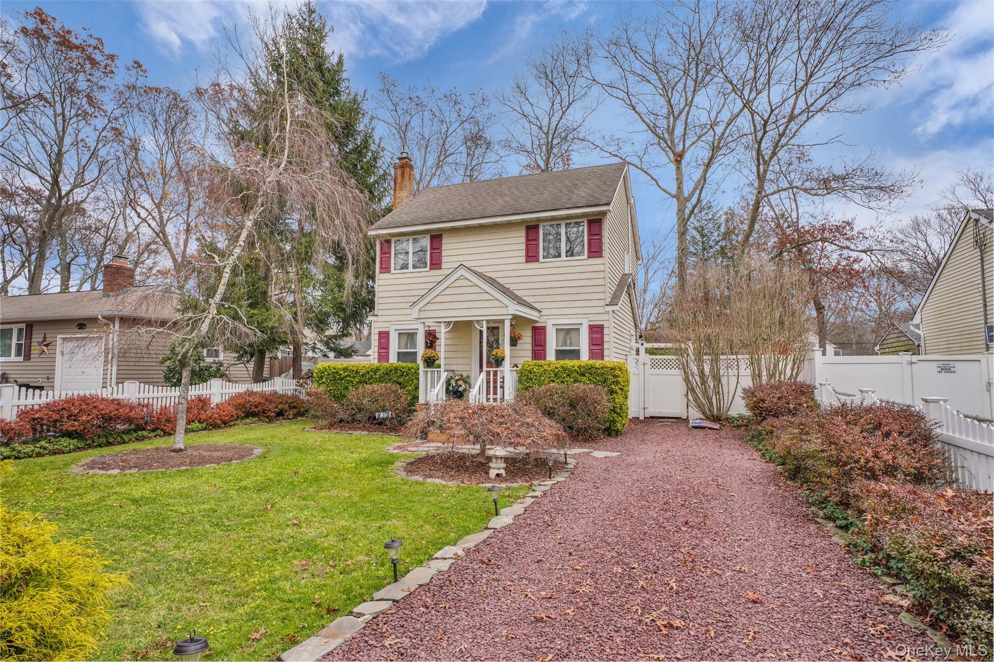 103 Wauwepex Trail Ridge, NY 11961 - Photo 2 of 25 a view of a white house with a yard table and chairs