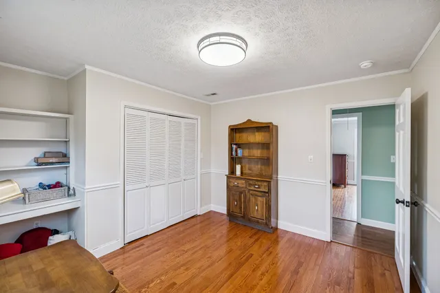 a view of empty room with wooden floor and cabinet