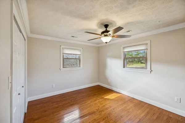 a view of empty room with wooden floor