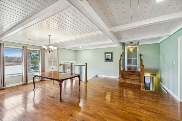 a kitchen with stainless steel appliances granite countertop a refrigerator a sink dishwasher and white cabinets with wooden floor