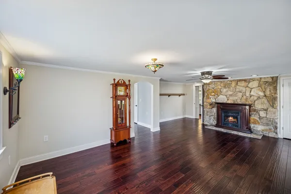 a view of a livingroom with wooden floor and a ceiling fan