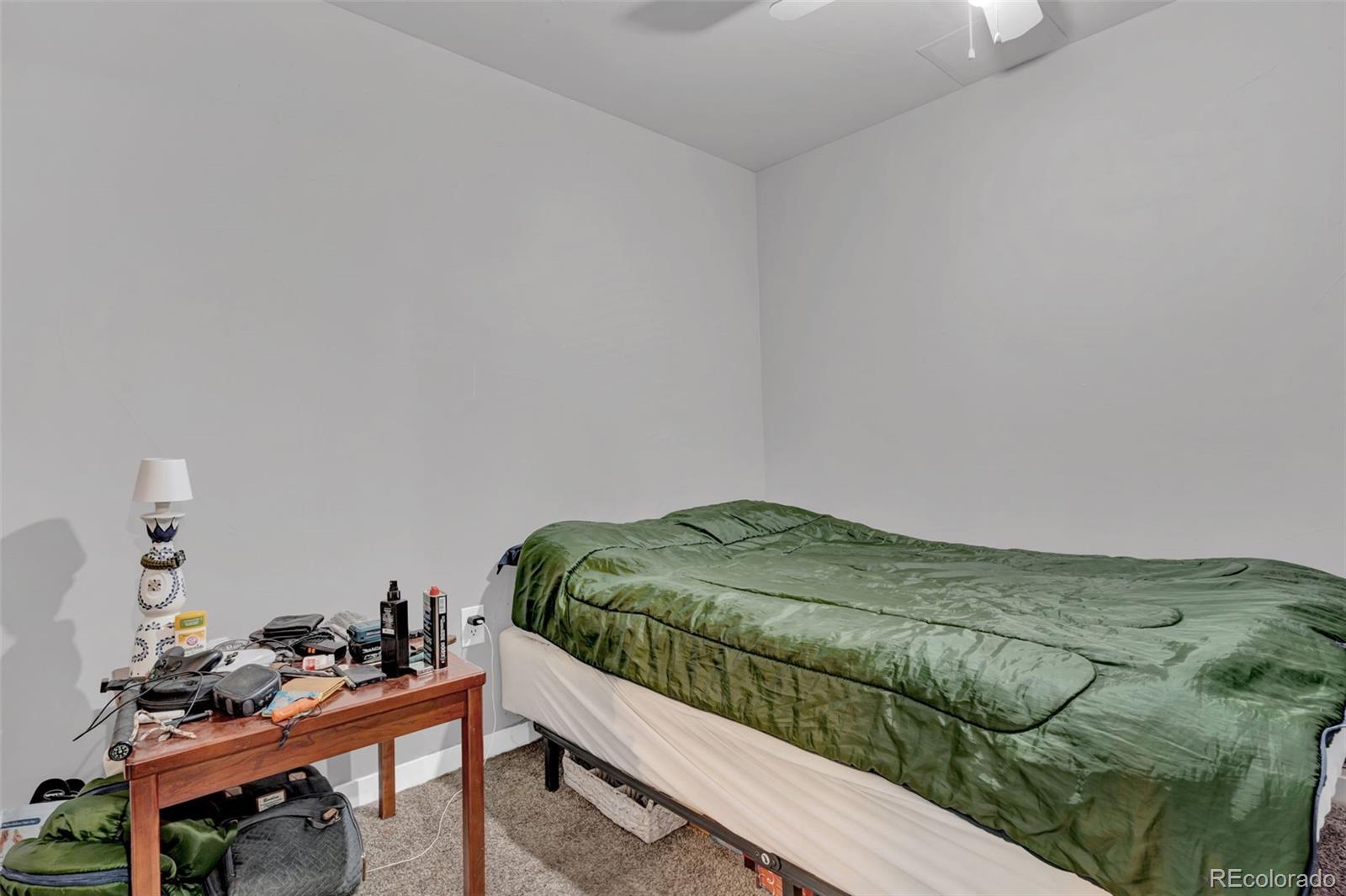 10656 Racine Circle Commerce City, CO 80022 - Photo 30 of 39 a bedroom with a bed and a chair