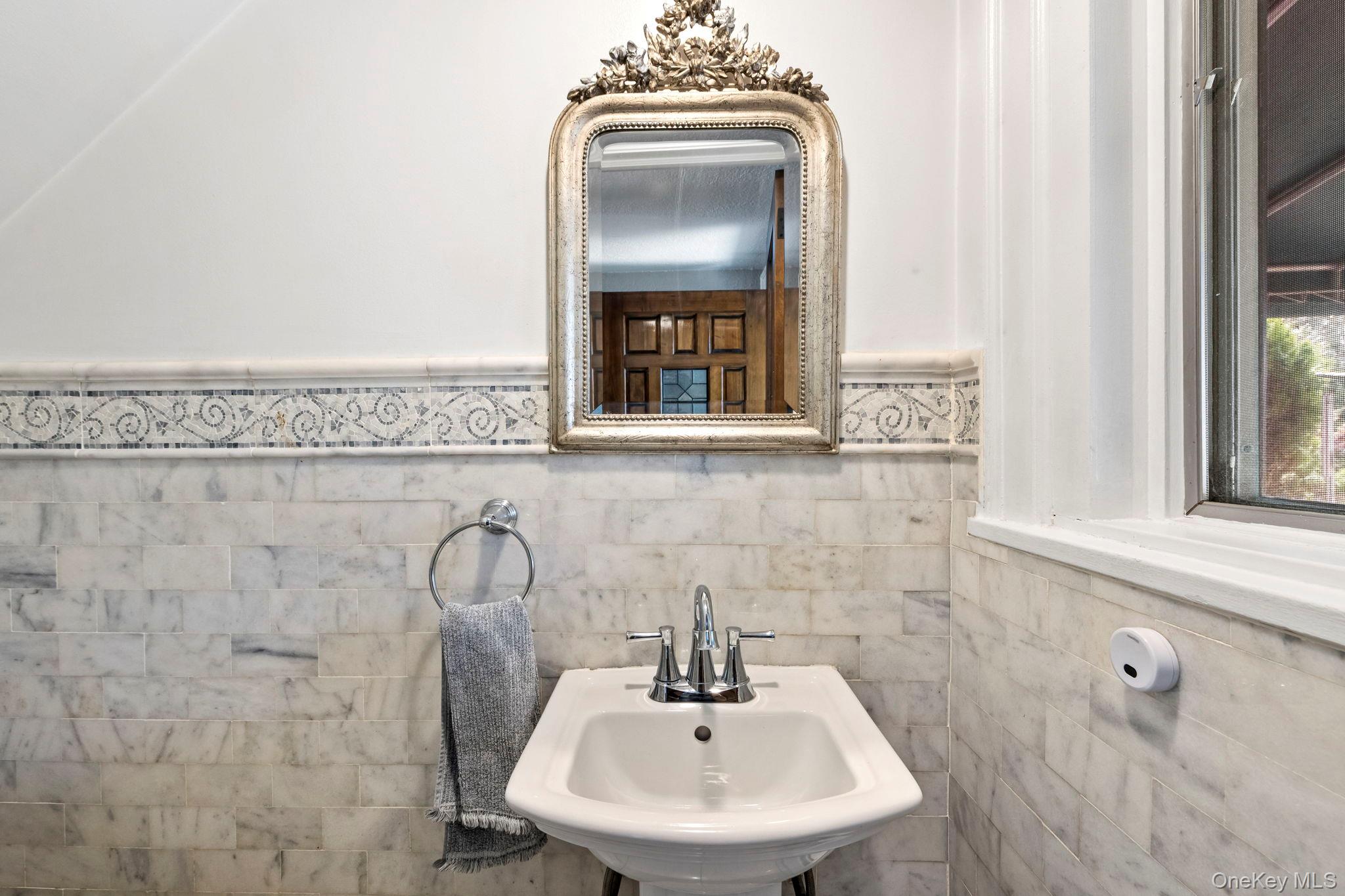 44 Fenimore Road New Rochelle, NY 10804 - Photo 10 of 46 a bathroom with a sink a mirror and a window