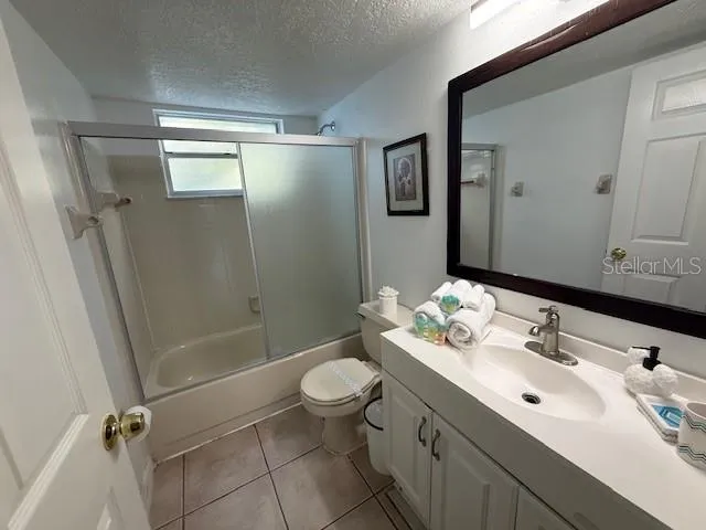 a bathroom with a sink a toilet a mirror and shower