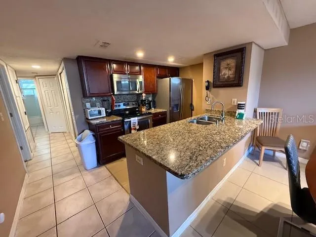 a kitchen with stainless steel appliances granite countertop a stove top oven a sink a counter top space and cabinets