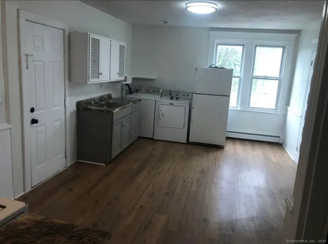a kitchen with wooden floors and white appliances