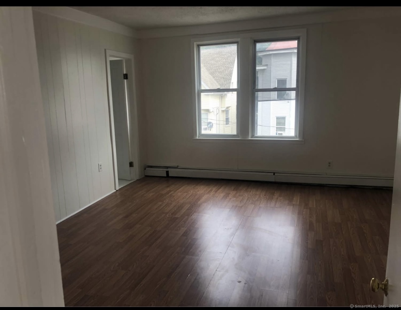 167 Chestnut Avenue, Unit 3 Waterbury, CT 06710 - Photo 7 of 10 an empty room with wooden floor and windows