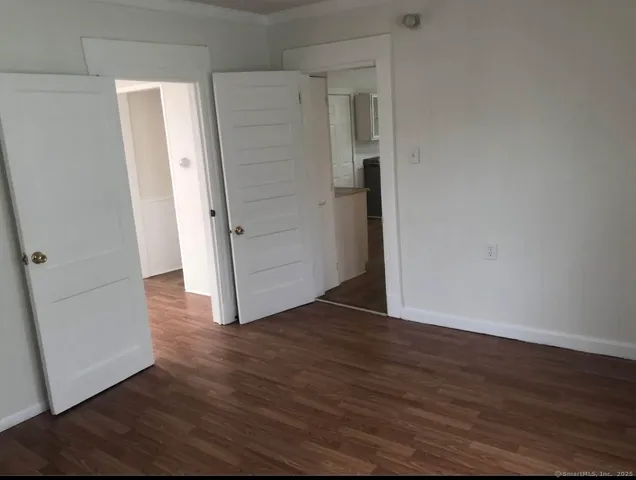 an empty room with wooden floor and entrance