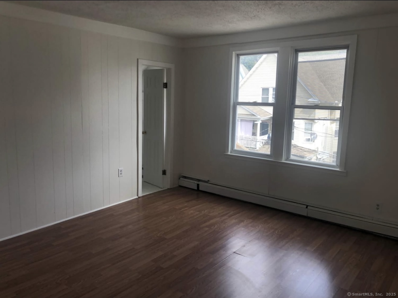 167 Chestnut Avenue, Unit 3 Waterbury, CT 06710 - Photo 9 of 10 an empty room with wooden floor and windows