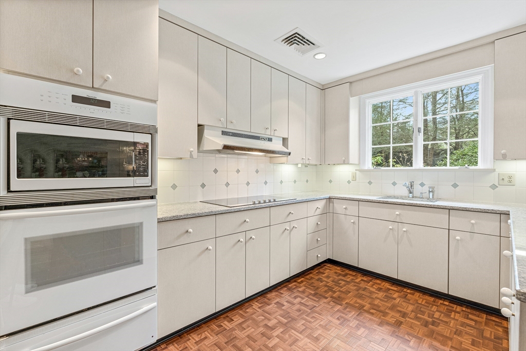 5 Deer Path Lane Weston, MA 02493 - Photo 12 of 26 a kitchen with granite countertop white cabinets stainless steel appliances and a sink