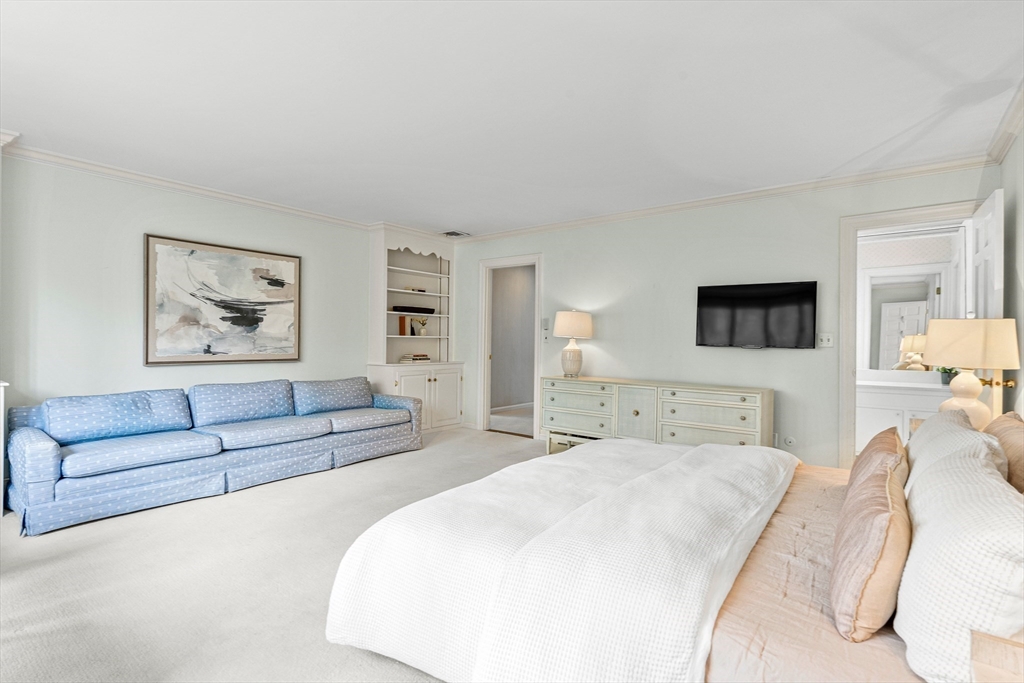 5 Deer Path Lane Weston, MA 02493 - Photo 16 of 26 a spacious bedroom with a bed a couch and a flat screen tv
