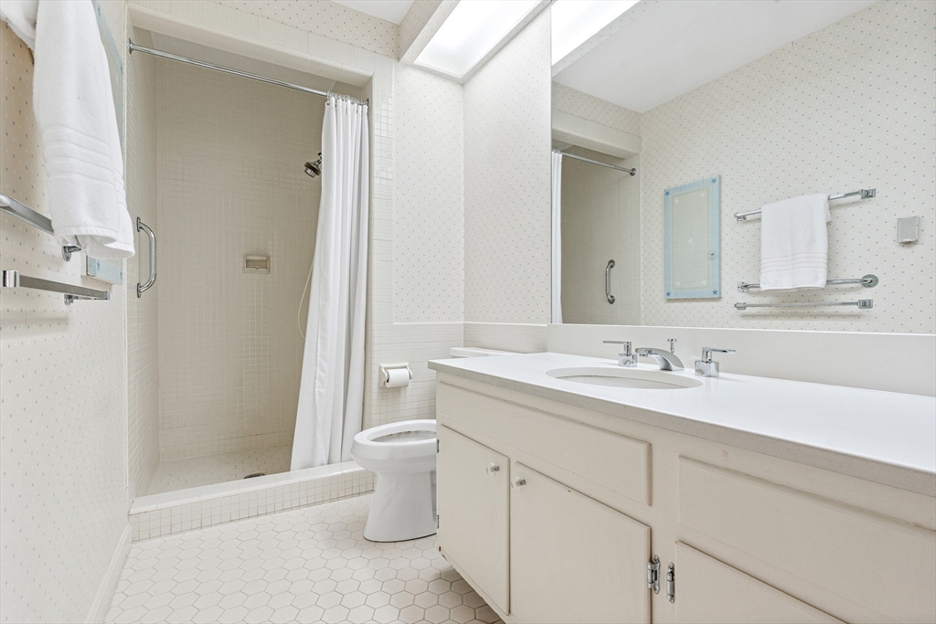 5 Deer Path Lane Weston, MA 02493 - Photo 19 of 26 a bathroom with a toilet a sink a mirror a shower a vanity and window