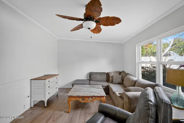 a living room with furniture ceiling fan and a window