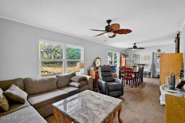 a living room with furniture a dining table and a chandelier