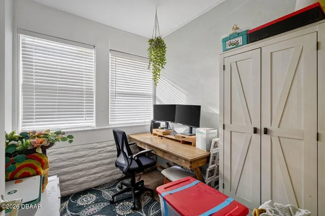 a view of a workspace with furniture and a window