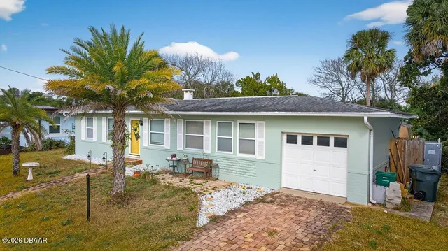 a front view of house with yard and trees around