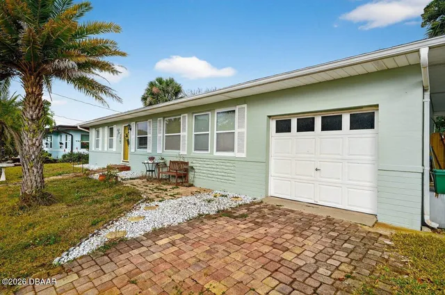 a front view of a house with a yard outdoor seating and garage
