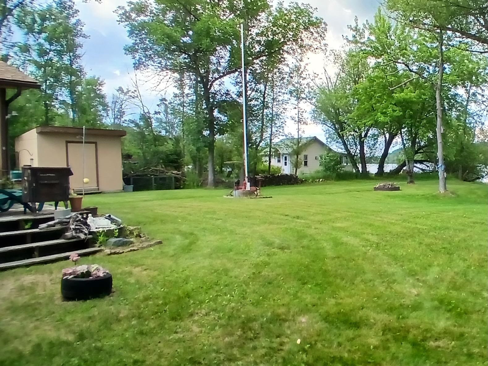 10922 South Stone Road Solon Springs, WI 54873 - Photo 11 of 64 View of green lawn featuring a storage shed and view of scattered trees