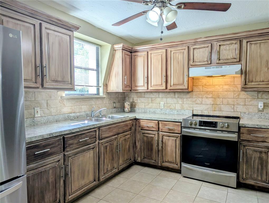 18001 Nelson Road Spring Hill, FL 34610 - Photo 17 of 29 a kitchen with stainless steel appliances granite countertop a stove sink and cabinets