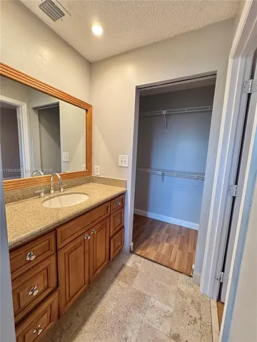 a bathroom with a granite countertop sink and a mirror