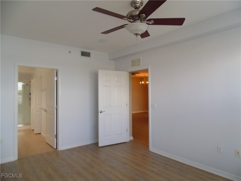 2615 Somerville Loop, Unit 303 Cape Coral, FL 33991 - Photo 17 of 40 an empty room with wooden floor closet and ceiling fan