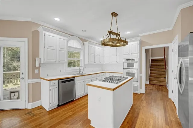 a kitchen that has a sink stainless steel appliances a counter space and a window