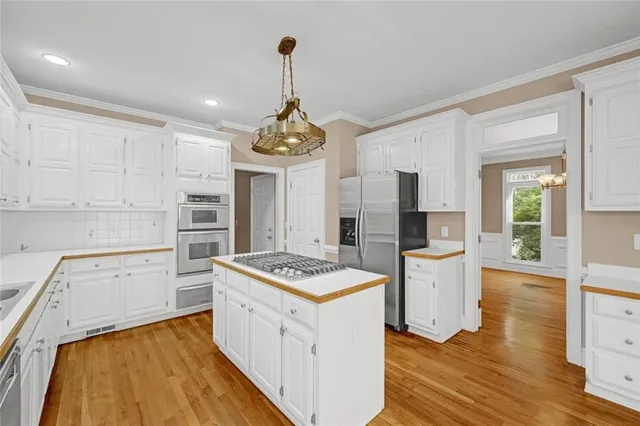 a kitchen with stainless steel appliances a stove top oven a counter space and cabinets