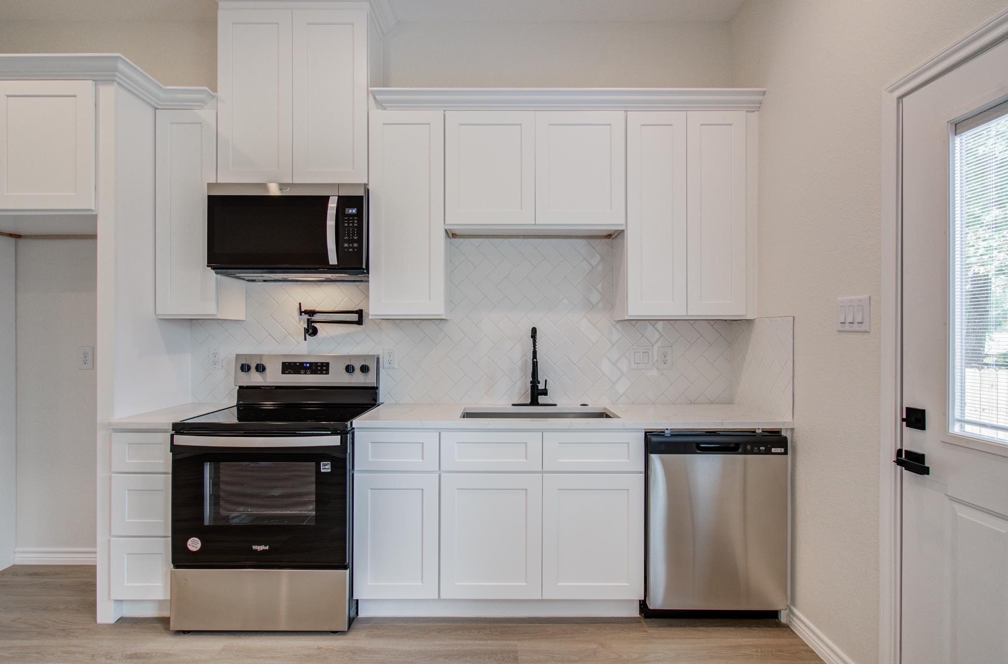 15301 Coaltown Road Willis, TX 77378 - Photo 19 of 38 a kitchen with white cabinets and stainless steel appliances