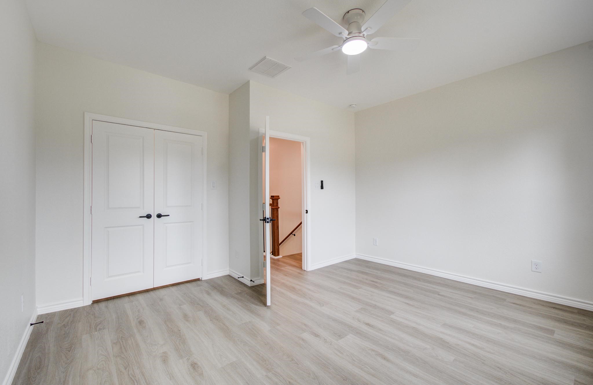 15301 Coaltown Road Willis, TX 77378 - Photo 27 of 38 an empty room with wooden floor and ceiling fan