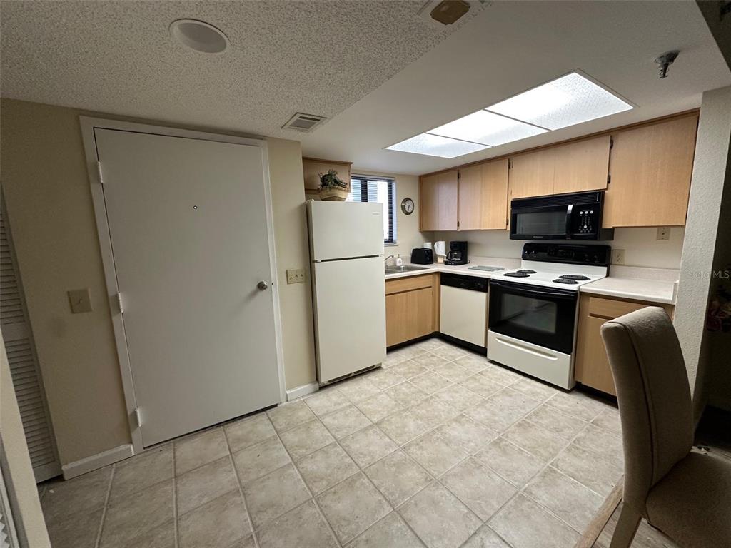 5915 Sea Ranch Drive, Unit 511 Hudson, FL 34667 - Photo 3 of 10 a kitchen with stainless steel appliances granite countertop a stove top oven a sink and a refrigerator