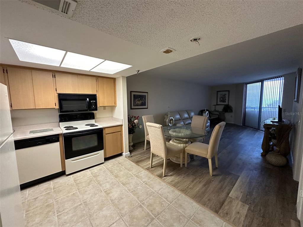 5915 Sea Ranch Drive, Unit 511 Hudson, FL 34667 - Photo 5 of 10 a living room with furniture a flat screen tv and kitchen view