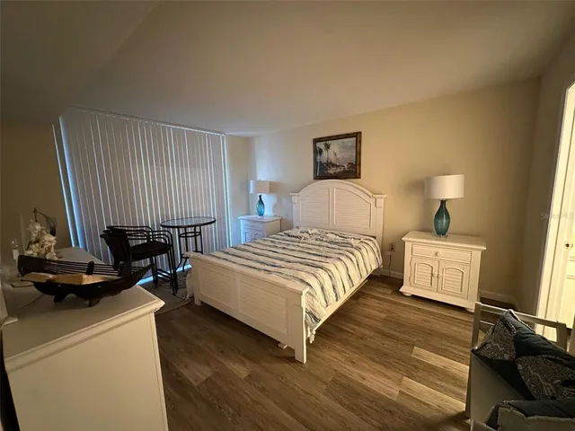 a bedroom with a bed a mirror and lamp