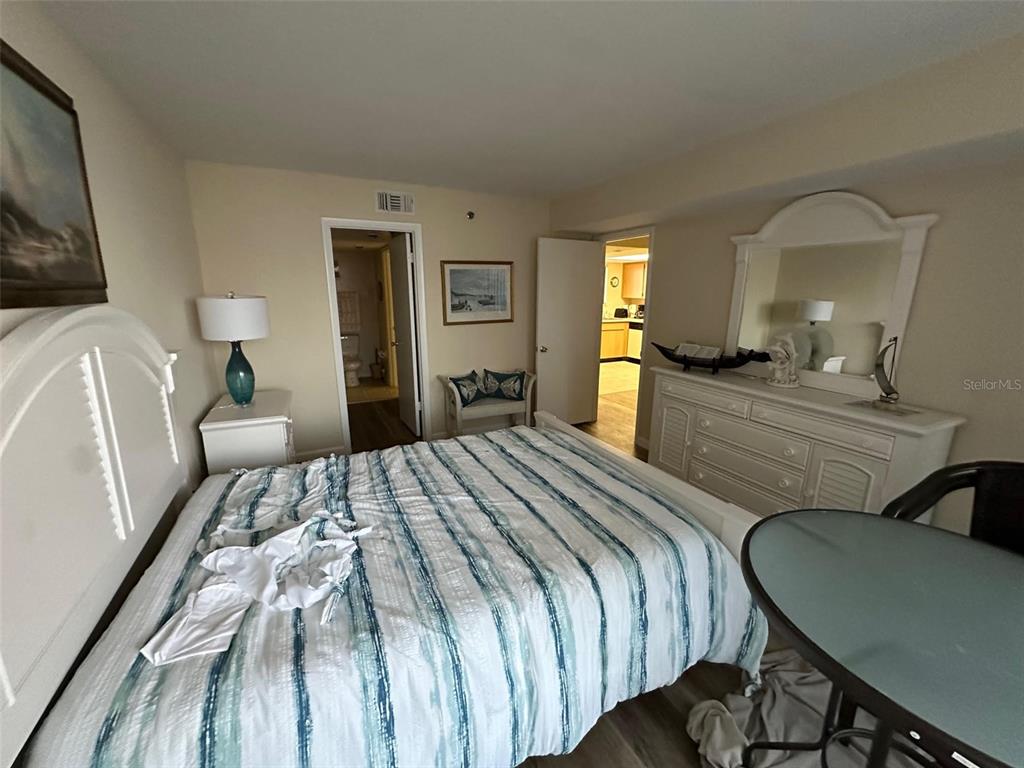 5915 Sea Ranch Drive, Unit 511 Hudson, FL 34667 - Photo 8 of 10 a bedroom with a bed a mirror and lamp