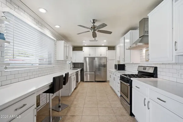 a kitchen with cabinets and chairs