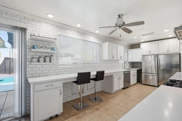 a kitchen with stainless steel appliances granite countertop a stove a sink and a refrigerator