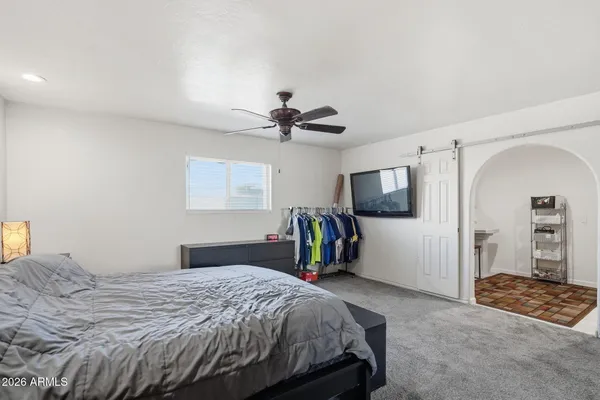 a bedroom with a bed a couch and dresser