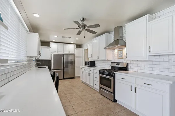 a kitchen with white cabinets and appliances