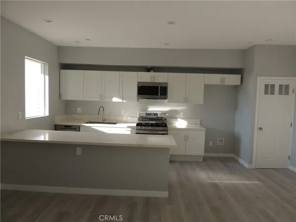 a kitchen with granite countertop a sink and a stove top oven