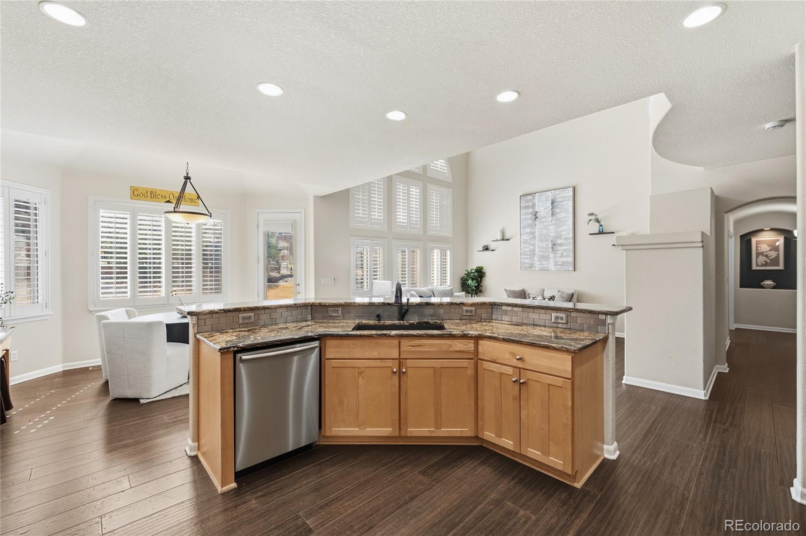 22426 East Roxbury Place Aurora, CO 80016 - Photo 14 of 50 a kitchen with granite countertop a sink and wooden cabinets