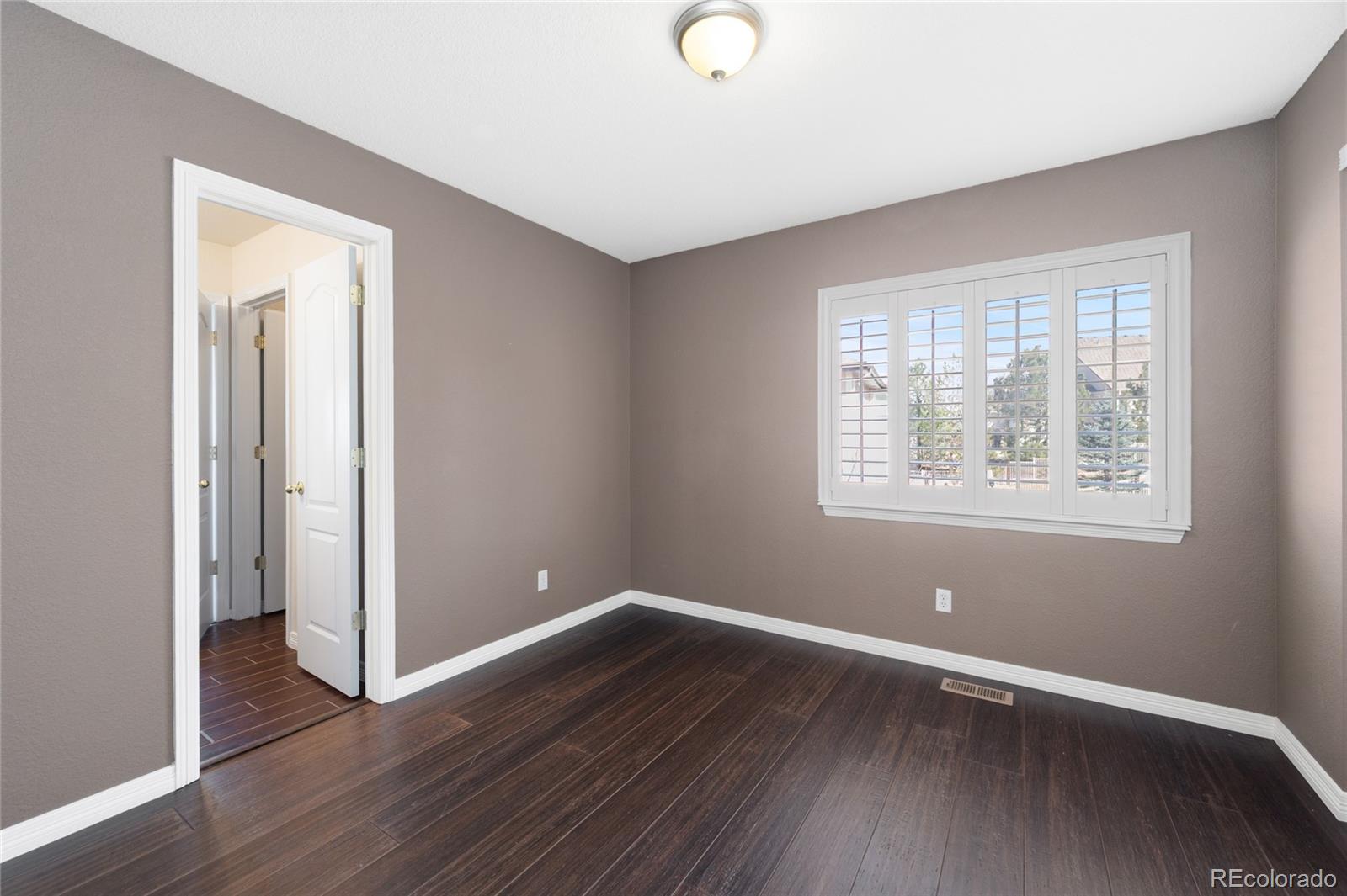 22426 East Roxbury Place Aurora, CO 80016 - Photo 33 of 50 an empty room with wooden floor and windows
