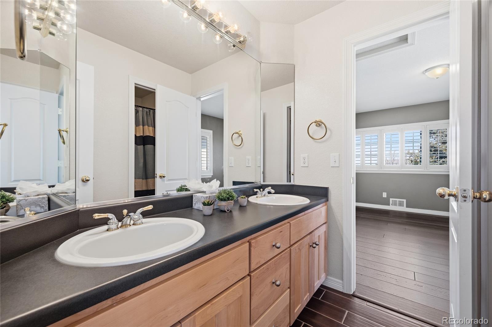 22426 East Roxbury Place Aurora, CO 80016 - Photo 35 of 50 a bathroom with double vanity sinks and a mirror