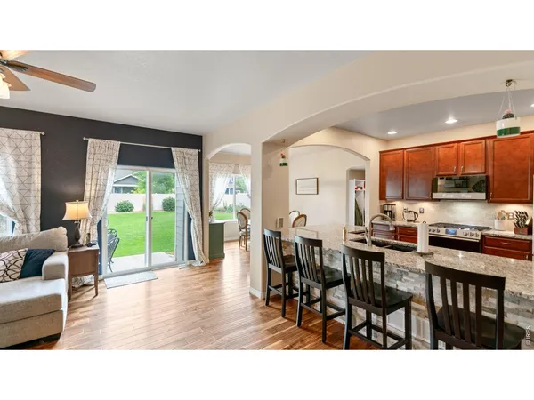 a living room with stainless steel appliances kitchen island granite countertop a dining table chairs and view living room