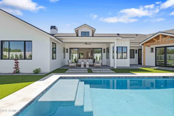 a view of a house with swimming pool and sitting area