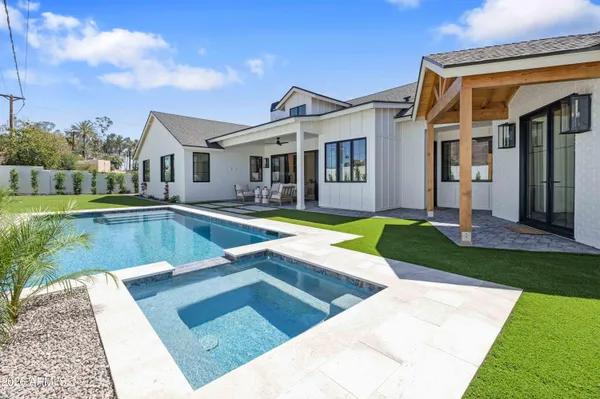 a view of a house with swimming pool and yard