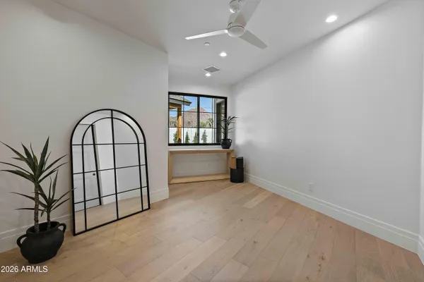 an empty room with windows and ceiling fan