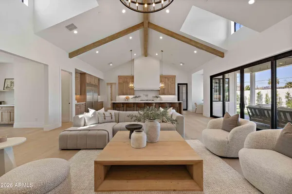 a living room with furniture a large window and a chandelier